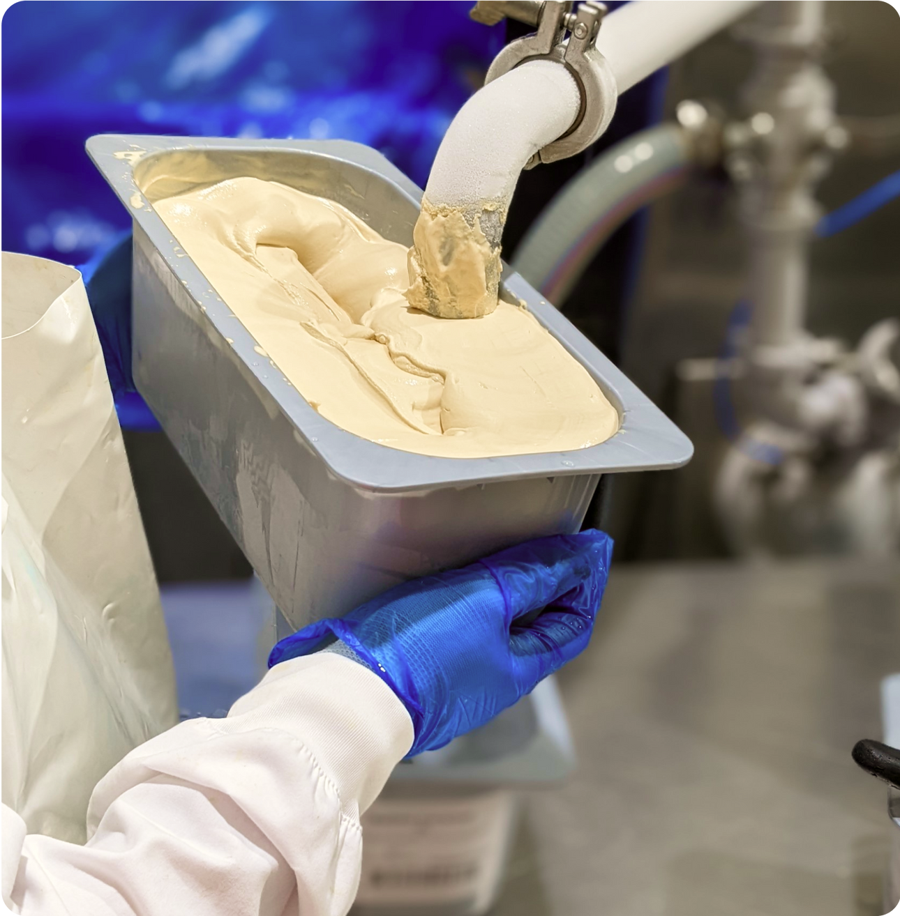 gelato being produced in bulk at a factory by a worker